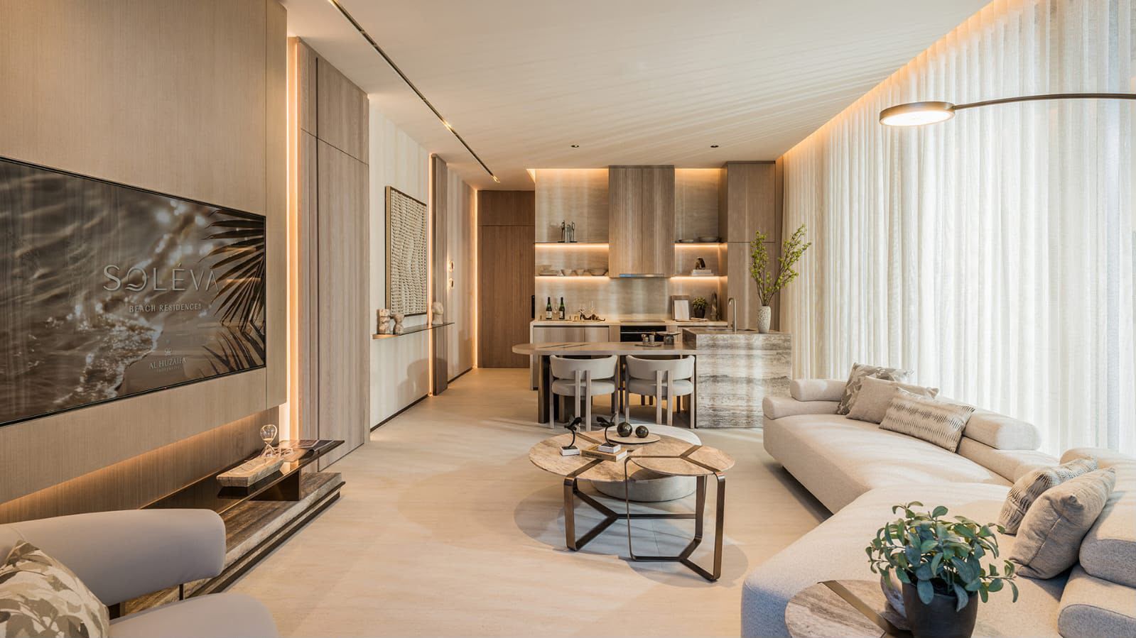 Open-plan studio interior with a living area, kitchen and dining in warm neutral tones